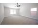 Bright bedroom with neutral carpet, ceiling fan, and natural light from large windows, creating a serene space at 10712 Aire Dr, Las Vegas, NV 89144