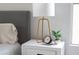 Stylish nightstand with a lamp, clock, and plant, next to a comfortable bed at 10712 Aire Dr, Las Vegas, NV 89144