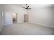 Spacious carpeted bedroom featuring a ceiling fan, neutral decor, and access to an ensuite bathroom at 10712 Aire Dr, Las Vegas, NV 89144