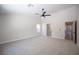 A carpeted bedroom featuring a ceiling fan, ensuite, and a hallway entrance at 10712 Aire Dr, Las Vegas, NV 89144
