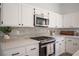 Kitchen with stainless oven, white cabinets, gray backsplash, large counters, and modern hardware at 10712 Aire Dr, Las Vegas, NV 89144