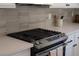 Modern kitchen features stainless steel gas range, neutral backsplash, and light countertop at 10712 Aire Dr, Las Vegas, NV 89144