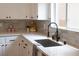 Kitchen sink with black faucet and white countertop, complemented by grey backsplash at 10712 Aire Dr, Las Vegas, NV 89144