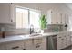 White cabinets and modern hardware, stainless appliances, and gray backsplash at 10712 Aire Dr, Las Vegas, NV 89144