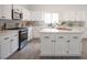Bright kitchen with white cabinets, stainless steel appliances, quartz countertops, and a large central island at 10712 Aire Dr, Las Vegas, NV 89144