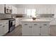 Kitchen with stainless appliances, white cabinets, large island, gray backsplash and modern hardware at 10712 Aire Dr, Las Vegas, NV 89144