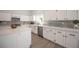 Bright kitchen featuring white cabinets, gray backsplash, stainless appliances, and an island at 10712 Aire Dr, Las Vegas, NV 89144