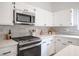 Close-up of a kitchen featuring stainless steel appliances, white cabinets, quartz countertops, and subway tile backsplash at 10712 Aire Dr, Las Vegas, NV 89144