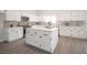 Bright kitchen with white cabinets, stainless steel appliances, quartz countertops, and a large central island at 10712 Aire Dr, Las Vegas, NV 89144