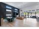 Open-concept living area featuring hardwood floors, tall windows, and stylish dining and lounging spaces at 10927 White Clay Dr, Las Vegas, NV 89135