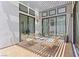 Inviting outdoor patio with stylish seating, wooden deck tiles, and large sliding glass doors at 10927 White Clay Dr, Las Vegas, NV 89135