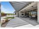 Expansive outdoor patio with shaded pergola, dining area, lounge seating, and manicured lawn at 10927 White Clay Dr, Las Vegas, NV 89135