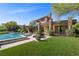Spacious backyard with a sparkling pool, lush green lawn, and a beautifully designed modern home at 11 Golden Sunray Ln, Las Vegas, NV 89135