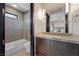 Bathroom featuring sleek vanity, toilet, and a glass-enclosed shower-tub combination at 11 Golden Sunray Ln, Las Vegas, NV 89135