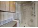 Stylish bathroom with tiled walk-in shower, storage cabinet, and seating at 11 Golden Sunray Ln, Las Vegas, NV 89135