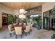 Bright dining room featuring a round table, elegant chandelier, large windows and beautiful plants and greenery at 11 Golden Sunray Ln, Las Vegas, NV 89135