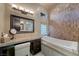 Elegant bathroom featuring a built in vanity, soaking tub with tile backsplash and modern fixtures at 11 Golden Sunray Ln, Las Vegas, NV 89135