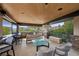 Covered patio area with outdoor seating, modern table, and folding glass doors at 11 Golden Sunray Ln, Las Vegas, NV 89135