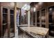 Luxurious walk-in closet with custom cabinetry, granite island, and abundant natural light from a skylight at 11 Golden Sunray Ln, Las Vegas, NV 89135