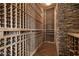 Well-appointed wine cellar with wooden racking system and stone accent wall at 11 Golden Sunray Ln, Las Vegas, NV 89135