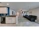 Open-concept living room and kitchen area with modern white cabinetry and granite countertops at 1130 E Dorrell Ln, North Las Vegas, NV 89086