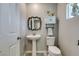 Charming half-bathroom with pedestal sink and decorative mirror at 1130 E Dorrell Ln, North Las Vegas, NV 89086