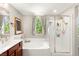Bright bathroom featuring a vanity, soaking tub, glass-enclosed shower, and a window providing natural light at 11402 Newton Commons Dr # 102, Las Vegas, NV 89135