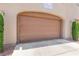 Garage with a brown garage door and paved driveway at 11402 Newton Commons Dr # 102, Las Vegas, NV 89135
