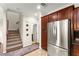 Hallway with access to stairs and kitchen area featuring stainless steel refrigerator and cabinets at 11402 Newton Commons Dr # 102, Las Vegas, NV 89135