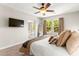 Bedroom showcasing neutral colors, ceiling fan, wall-mounted TV, and view to en-suite bathroom with shower at 11402 Newton Commons Dr # 102, Las Vegas, NV 89135