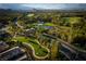 Picturesque aerial view of a golf course community with lush greenery, a pond, and luxury homes at 11830 Kingsbarns Ct, Las Vegas, NV 89141