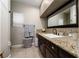 Bathroom featuring granite counters, dark wood cabinets, and modern tile flooring at 11830 Kingsbarns Ct, Las Vegas, NV 89141
