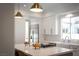 Bright kitchen featuring a kitchen island with cooktop and white countertops and cabinetry at 11830 Kingsbarns Ct, Las Vegas, NV 89141
