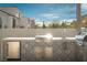 Well-equipped outdoor kitchen featuring a stainless steel grill, sink, and patterned backsplash for stylish outdoor cooking at 11830 Kingsbarns Ct, Las Vegas, NV 89141