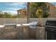 Fully equipped outdoor kitchen featuring stainless steel appliances, grill, and stylish patterned backsplash at 11830 Kingsbarns Ct, Las Vegas, NV 89141
