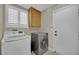 Bright laundry room featuring a modern washer and dryer set, built-in storage, and access to the exterior at 1335 Passiflora Dr, Henderson, NV 89002