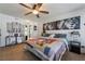 A spacious bedroom with a ceiling fan, a large bed, and lion artwork on the wall at 1575 W Warm Springs Rd # 2822, Henderson, NV 89014