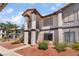 Two-story apartment with stairs, red rock landscaping, light stucco, and dark brown trim at 1575 W Warm Springs Rd # 2822, Henderson, NV 89014