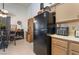 Cozy kitchen featuring a black refrigerator, light brown cabinets, and dining table at 1575 W Warm Springs Rd # 2822, Henderson, NV 89014