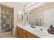 Bright bathroom with dual sinks, a large mirror with vanity lighting, and separate shower and toilet rooms at 1906 Desert Sage Ave, North Las Vegas, NV 89031