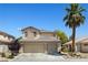 Two-story home featuring a 3-car garage, desert landscaping, and a tall palm tree at 1906 Desert Sage Ave, North Las Vegas, NV 89031