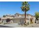 Attractive two-story home with a well-manicured lawn, mature palm tree, and a three car garage at 1906 Desert Sage Ave, North Las Vegas, NV 89031