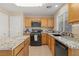 Well-lit kitchen features an island, granite counters, and stainless steel appliances at 1906 Desert Sage Ave, North Las Vegas, NV 89031