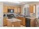 Modern kitchen features granite countertops, wood cabinets, and stainless steel appliances at 1906 Desert Sage Ave, North Las Vegas, NV 89031