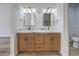 Elegant bathroom featuring double sinks with framed mirrors, custom wooden cabinetry, and stylish fixtures at 2117 Desert Peak Rd, Las Vegas, NV 89134