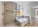 Elegant bathroom showcasing a glass-enclosed shower, luxurious tub, and stylish chandelier at 2117 Desert Peak Rd, Las Vegas, NV 89134