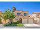 Charming two-story home with a well-manicured lawn, desert landscaping, and a classic tile roof under a clear blue sky at 2117 Desert Peak Rd, Las Vegas, NV 89134