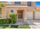 Inviting front entrance with a well-kept lawn and mature landscaping accentuating the covered entryway to the home at 2117 Desert Peak Rd, Las Vegas, NV 89134
