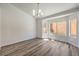 Bright living room featuring wood-look floors, crisp white walls, and a modern chandelier fixture at 2117 Desert Peak Rd, Las Vegas, NV 89134