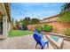 Inviting back yard featuring string lights, paver patio, blue Adirondack chairs, and a playhouse at 2433 Amatrice St, Henderson, NV 89044